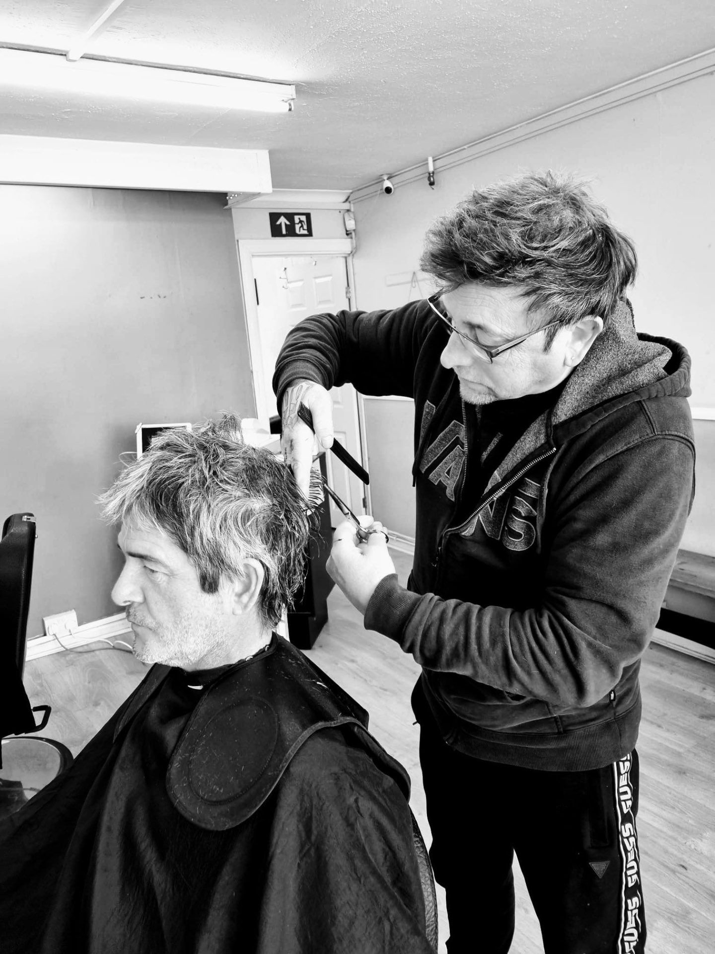 Sean cutting a client's hair with scissors