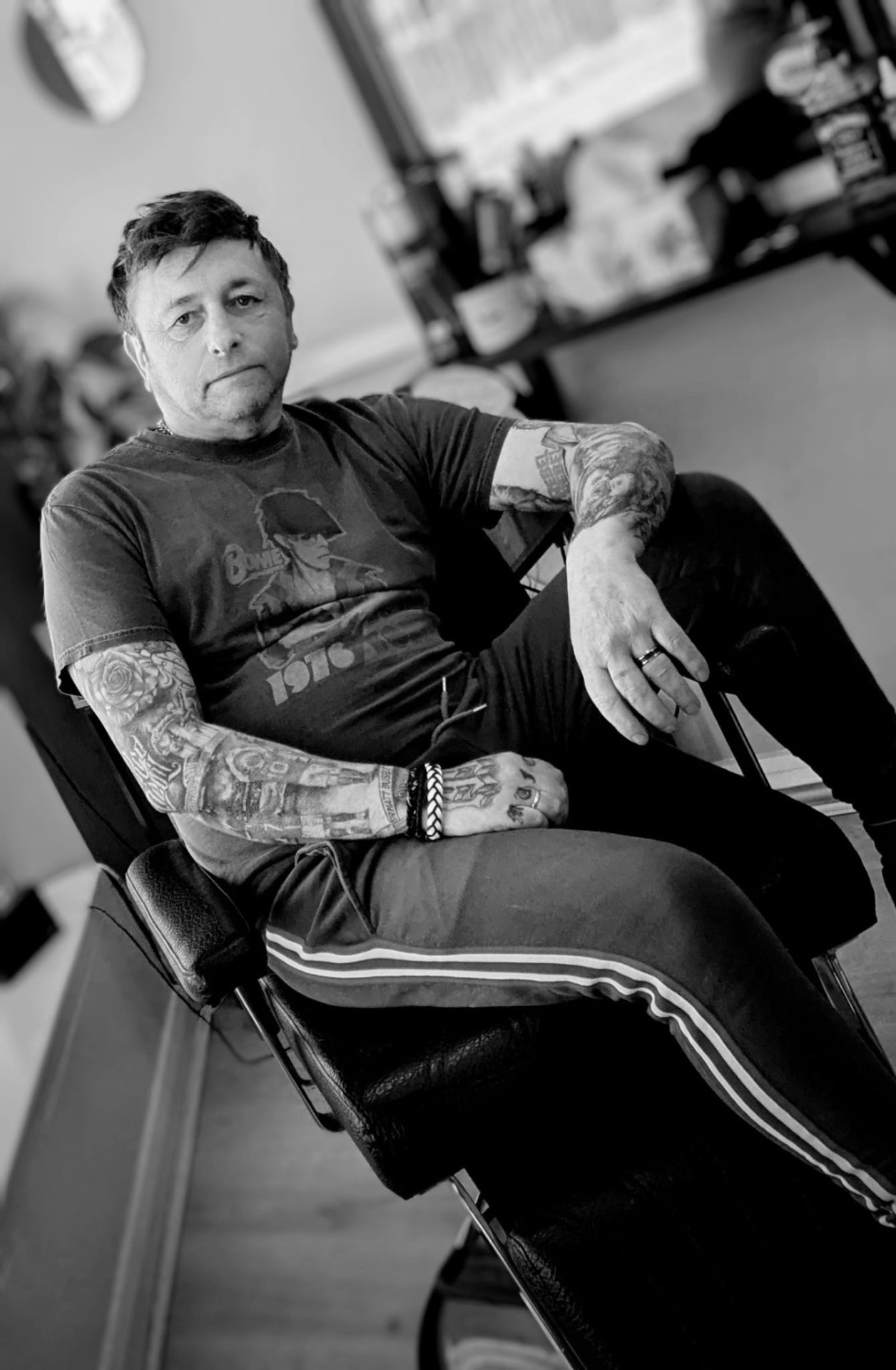 Black and white portrait of Sean relaxing in a barber's chair